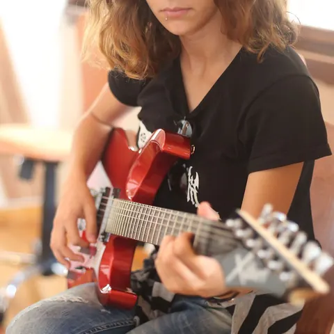 Elektro gitarın telleri ve klavyesinde yakın plan çalışma