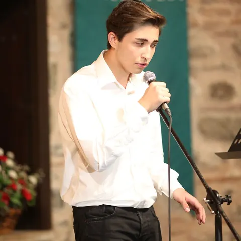 Mikrofonla şarkı söyleyen öğrenci