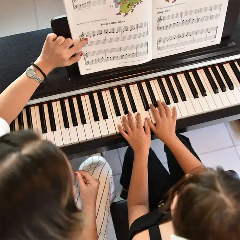 Piyano dersinde klavye ve nota kitabının üstten görünümü