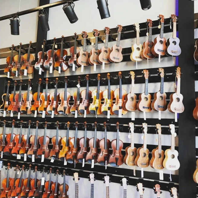 Mağaza duvarında farklı boylarda kemanlar ve ukuleleler