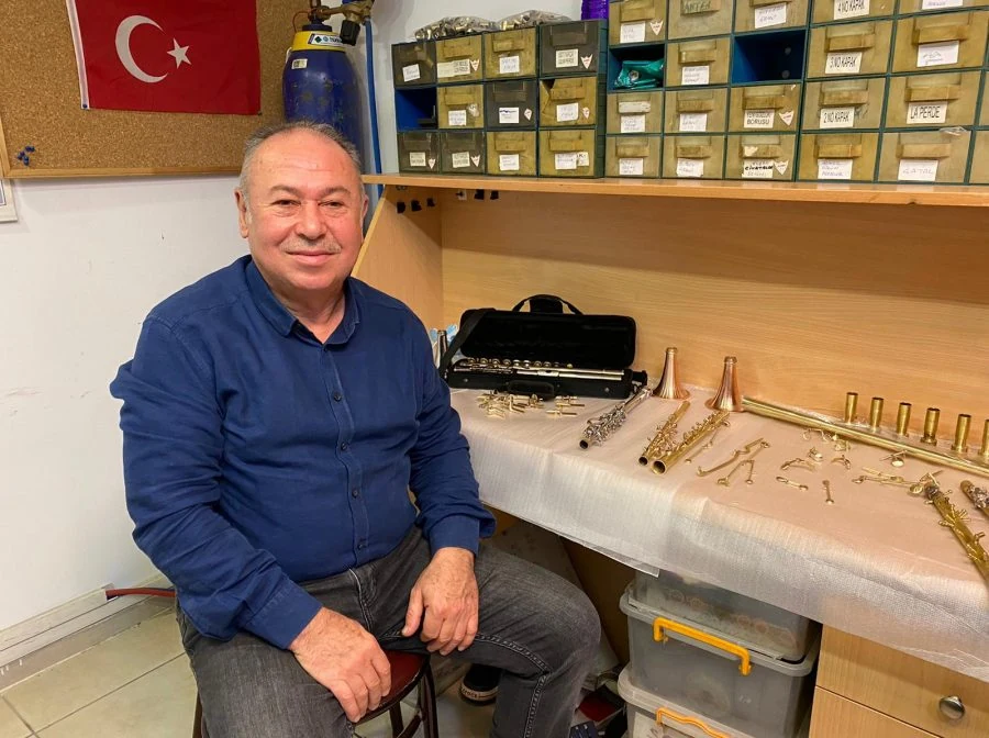 Ramazan Kor, klarnet parçalarının bulunduğu çalışma tezgâhının yanında; 2020 tarihli röportaj fotoğrafı