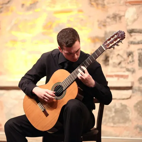 Klasik gitarla sahnede solo performans
