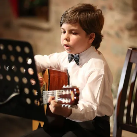 Çocuk öğrencinin klasik gitar performansı