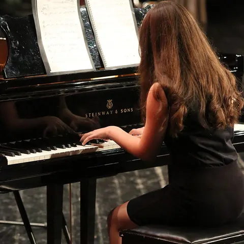 Piyano performansının klavye ve nota sehpasıyla yakın görünümü