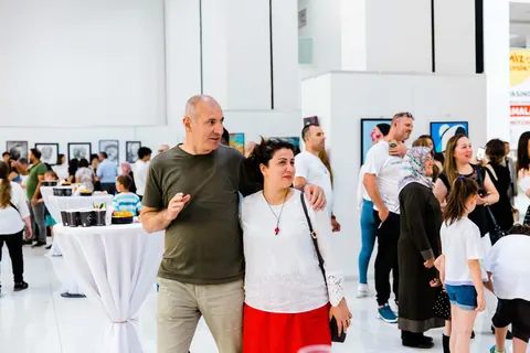 Sergi salonunda birlikte fotoğraf çektiren ziyaretçiler