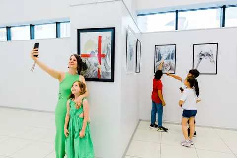 Karakalem eserlerin önünde fotoğraf çektiren ziyaretçiler