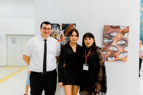 Öğrenci çalışmalarının önünde sergiden bir hatıra